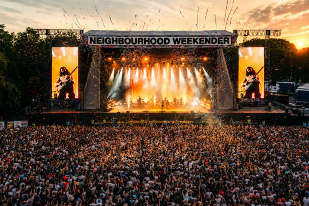 A huge crowd fills Victoria Park in front of the main stage at dusk during Neighbourhood Weekender, tied to the festival's 2027 lineup announcement.