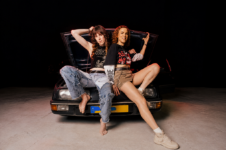 Octo Octa and Eris Drew announce their debut LP as Alchemical Sisters, posing back-to-back against a vintage car in press art for the October 18 Interdimensional Transmissions release.