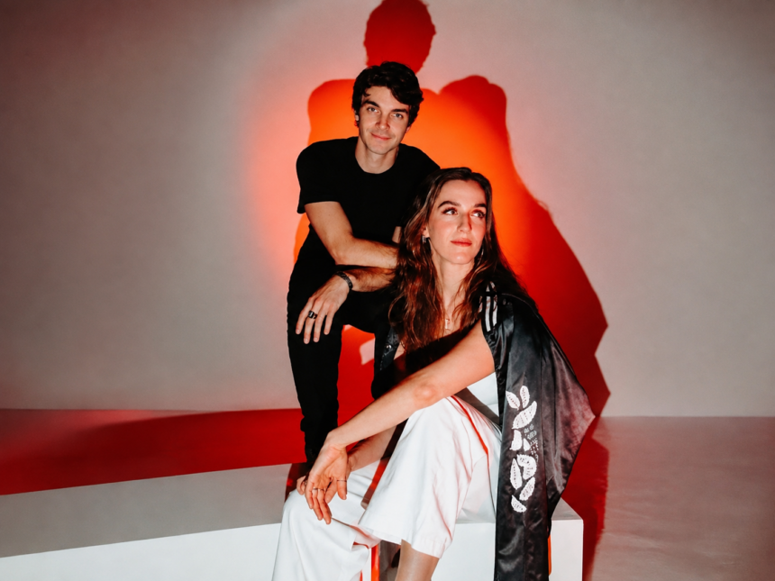 Reality Distortion, whose debut EP 'Ceasefire' is out now, pose against a red-lit backdrop in a moody sibling-duo portrait.