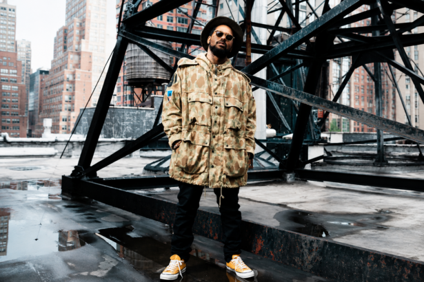 ScHoolboy Q, announcing his 'Blank Face LP' 10-year anniversary tour, poses in a camo parka and hat on a city rooftop