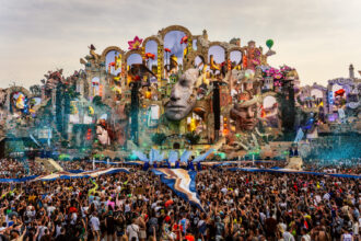 Tomorrowland 2026's record-breaking Consciencia mainstage, with its giant sculpted faces and arches, towers over the crowd in Boom, Belgium.