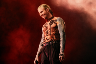 What So Not performs live against a red-lit backdrop, smiling with a mic in hand and wearing a patterned mesh top, in press-style art tied to his new project and tour.