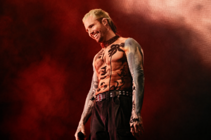 What So Not performs live against a red-lit backdrop, smiling with a mic in hand and wearing a patterned mesh top, in press-style art tied to his new project and tour.