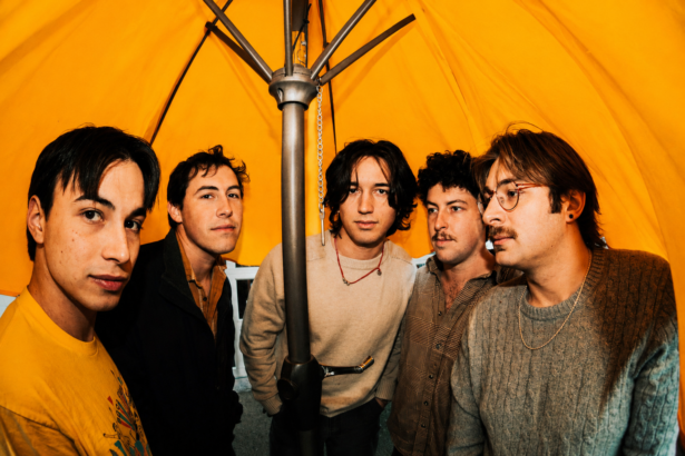 Athens band superstar, whose single 'stray' with Florence Cardigan is out now, pose under a bright yellow umbrella in a press photo.