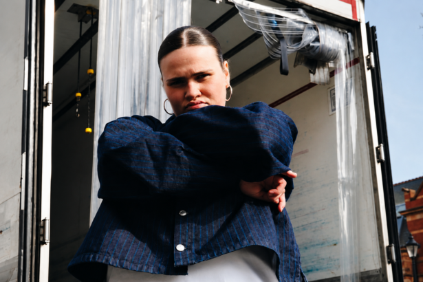 venbee 'Back to the Drawing Board' EP press shot, the Kent singer in a navy pinstripe jacket against a truck doorway.