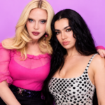Madonna and Charli xcx posing together against a pink backdrop, one in a pink blouse and one in a studded silver top