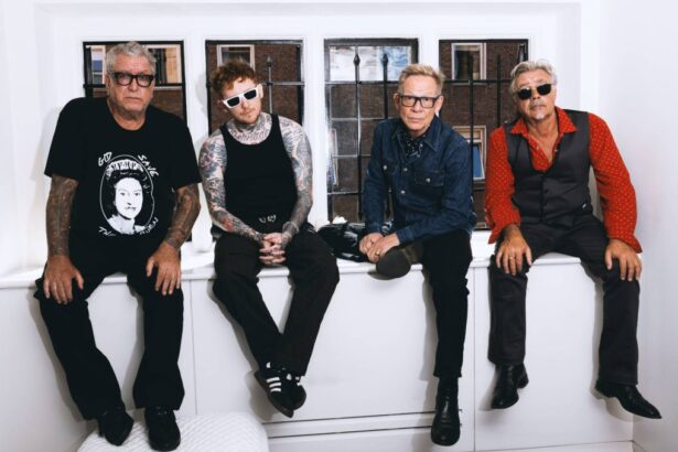 The Sex Pistols with frontman Frank Carter sit together by a window in a press photo, tied to their 2026 '50 Years of Punk' UK tour.