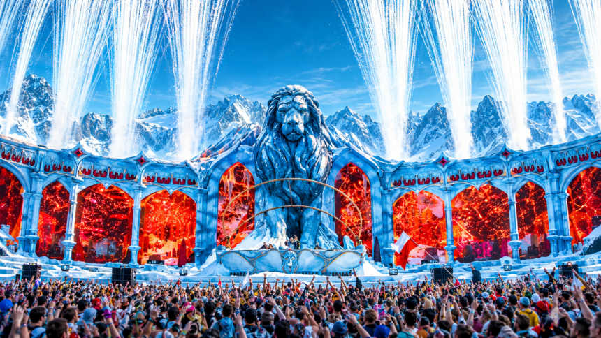 Tomorrowland Winter 2027 poster showing the festival's lion mainstage against snowy mountains with pyrotechnics and a packed crowd, captioned March 20 to 27, 2027, Alpe d'Huez, France.