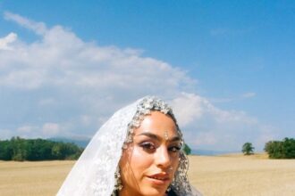 BombayMami in an embellished white bridal look and lace veil in a wheat field, promoting ‘Honey Liquor.’
